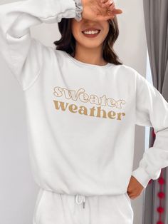 Bundle up, buttercup! Our "Sweater Weather" Sweatshirt is here to wrap you in a cozy embrace warmer than your ex's apology text. This isn't just a sweatshirt – it's a wearable ode to that magical time of year when leaves turn crisp and your dating standards turn flexible. Perfect for sipping pumpkin spice lattes, pretending to enjoy football, or aggressively cuddling your cat while scrolling through dating apps. With this sweatshirt, you're not just embracing autumn, you're practically french-ki Trendy Winter Tops With Comfortable Fit, Trendy Comfortable Winter Tops, Trendy Comfortable Fit Tops For Winter, Comfy Sweats For Winter Leisure, Comfy Sweats For Leisure In Winter, Comfy Winter Sweats For Leisure, Winter Leisure Sweater With Letter Print, Cozy Spring Sweater With Letter Print, Cozy Letter Print Sweater For Spring