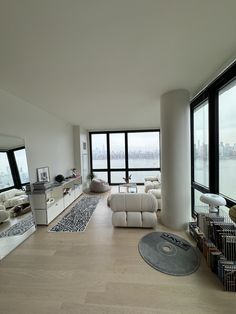 a living room filled with furniture and large windows