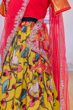 Look no further for a perfect festive outfit than this ravishing Yellow and Crimson Red Kanchi Pen Kalamkari Lehenga. This distinctive combination of enchanting colors will surely make you the center of attention. Perfect for special occasions, its luxurious fabric and intricate details will captivate every onlooker. Make a bold statement with this one-of-a-kind ensemble. Transitional Lehenga With Dupatta, Red Cotton Silk Wedding Sets, Designer Red Tissue Silk Sharara, Festive Cotton Silk Choli With Zari Work, Red Cotton Silk Traditional Wear For Navratri, Red Cotton Silk Sharara For Festivals, Festive Cotton Silk Choli, Red Tissue Silk Sharara With Cutdana, Festive Designer Sharara With Kalamkari Print