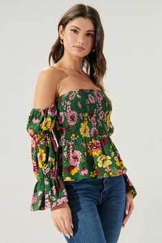 Autumn is in full bloom in the Everly Floral Off the Shoulder Smocked Peplum Top. Perfect for warmer autumn days, this top features a smocked bodice with a peplum waist. Smocked off the shoulder sleeves are attached. Complete the look with light wide leg pants and strappy heels for a flirty look.- Smocked bodice- Off the shoulder- Smocked sleeves- Peplum- Color: Green MultiSize + Fit - Model is 5'9" and wearing size XS- Measurements taken from size S - Chest: 29"- Length: 31 1/2" fabricSelf: 100 Off-shoulder Top With Smocked Bodice For Fall, Spring Ruffled Tops For Gatherings, Spring Peasant Top With Smocked Back, Green Summer Blouse With Smocked Cuffs, Summer Green Blouse With Smocked Cuffs, Long Sleeve Floral Smocked Top For Brunch, Green Long Sleeve Smocked Top, Long Sleeve Smocked Top With Floral Print For Brunch, Spring Brunch Blouse With Smocked Bodice