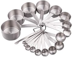 an assortment of stainless steel measuring spoons arranged in a circle on a white background