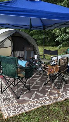 a tent set up with chairs and tables in front of it on top of a rug