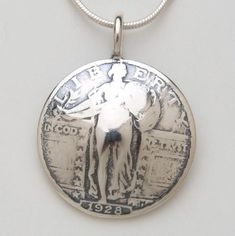 Pendant made from a vintage silver American Standing Liberty quarter coin.  There is an eagle on the reverse side.  I do not have a picture of it at this time.  It comes on a sterling silver bead chain, not the snake chain pictured.  Please select your preferred length.  To make one of these pieces, the face is sanded off on one side of a coin (except for those pieces with the coin image on both sides). Then using traditional hammering and forging techniques, the shape is formed, the designs are Vintage Silver Coin Jewelry, Vintage Stamped Jewelry For Commemoration, Vintage Commemoration Jewelry, Vintage Antique Silver Coin Jewelry, Vintage Sterling Silver Jewelry For Commemoration, Classic Stamped Coin Jewelry, Vintage Etched Jewelry For Commemoration, Collectible Coin-shaped Stamped Jewelry, Collectible Stamped Coin Jewelry