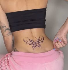 a woman with a butterfly tattoo on her lower back and the bottom part of her stomach