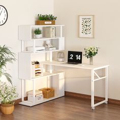 a white desk topped with a clock next to a plant and bookshelf on top of a hard wood floor