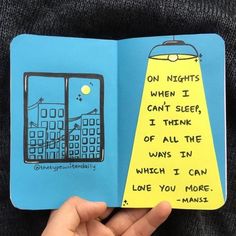 a hand holding an open book with writing on it and a drawing of a cell phone