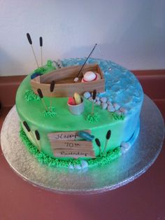 a birthday cake decorated with an image of a boat on the water and golf tees