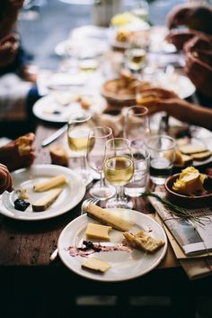 people sitting at a table with plates and wine glasses