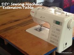 a white sewing machine sitting on top of a wooden table