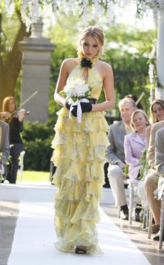 a woman in a yellow dress is walking down the aisle