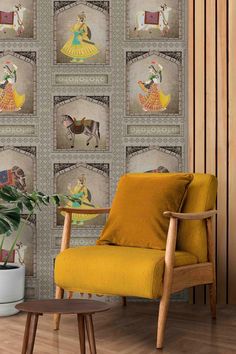 a yellow chair sitting in front of a wall with pictures on it and a potted plant