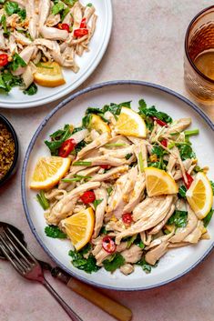 two plates of food on a table with silverware and glasses next to them,