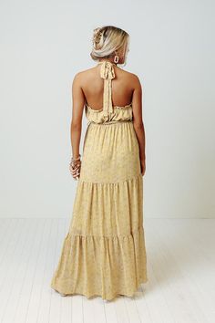 You are sure to feel nothing but happiness when you dress to impress in this beautiful primrose yellow colored maxi featuring lightweight flowy material patterned with a subtle floral print, a high neckline with a halter tie closure, ruffled trim detailing, a cinched waistline with a tie belt, and a relaxed tiered skirt silhouette that cascades into a straight ankle-length hemline! Yellow Tie Back Maxi Dress For Summer, Yellow Floral Print Halter Neck Maxi Dress, Chic Yellow Maxi Dress With Tie Back, Yellow Tie Back Maxi Dress For Vacation, Spring Yellow Halter Dress For Beach, Yellow Halter Dress For Spring Beach Outing, Yellow Halter Dress For Beach Spring Season, Yellow Halter Dress For Spring Beach, Yellow Halter Dress For Spring Beach Occasion