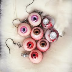 several pink and red eyeballs are shown on a white fur covered surface,