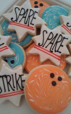 some decorated cookies are sitting in a white tray with words on them that say spare space and strike