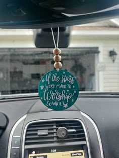 a car dashboard with a sign that says if the stars were made to worship so will i