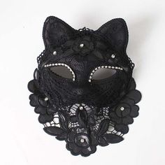 a black cat mask with pearls and lace