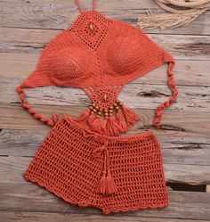 Soak up the sun with the bohemian flair of the Anissa Crochet Bikini Set, a must-have for your beach day escapades. This beautifully handcrafted two-piece swimsuit features intricate crochet detailing that exudes a laid-back, artisanal charm. The halter top is designed with a sensual neckline and openwork patterns that offer both coverage and a subtle peek of skin, while the matching high-waisted shorts with fringe trim add a playful touch to the ensemble. The wooden bead accents along the bodic Crochet Swimwear For Beach Party, Crochet Beachwear Swimwear For Vacation, Beachwear Crochet Swimwear For Vacation, Crochet Swimwear For Beachwear Vacation, Crochet Swimwear For Beach Party In Beach Season, Crochet Swimwear For Poolside Vacation, Crochet Swimwear For Beach Party During Beach Season, Crochet Swimwear For Beach, Crochet Swimwear For Summer Beach