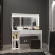 a white vanity with lighted mirror and stool next to it in a gray wall room