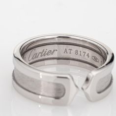 This is part of Chairish’s Fine Jewelry assortment.  Vintage Cartier Double C logo ring crafted in 18 karat white gold (circa 2000).    The out of production Cartier ring features a high polish outer bands with an inset satin finish. The ring is great worn alone or stacked with your fine jewelry from any era.  The ring is in very good condition and was recently lightly cleaned and polished. No box or papers.  Particulars:  Weight: 7.6 grams  Stones:  N/A  Size & Measurements: The ring is a size Cartier Logo, Vintage Solitaire Engagement Ring, Filigree Diamond Ring, Ruby Bands, Gold Statement Ring, Contemporary Ring, C Logo, Purple Band, Gold Band Ring