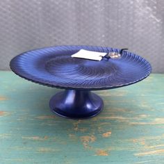 a blue cake plate with a tag on it