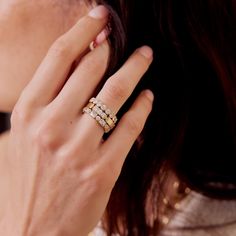 a close up of a woman's hand with a ring on her finger and two diamonds in the middle