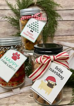 three jars filled with dog treats on top of a wooden table next to christmas decorations