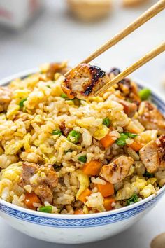 a close up of a bowl of food with chopsticks sticking out of it