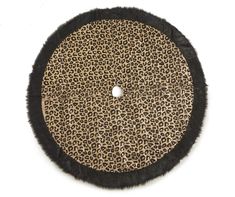 a round animal print rug with black fur trimmings on the bottom and sides