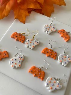 the orange and white elephant earrings are on display