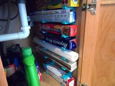 a bunch of books are stacked on top of each other in a closet under a sink