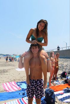 a man carrying a woman on his back at the beach