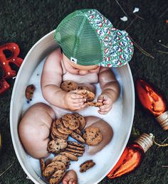 a baby sitting in a bath filled with cookies