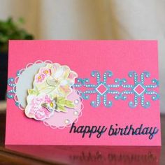 a pink card with flowers on it and the words happy birthday written in blue ink