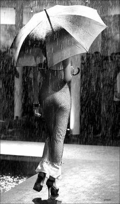 a woman walking in the rain with an umbrella over her head and heels on it