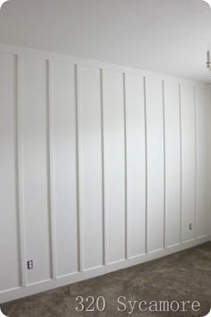 an empty room with white paneling on the walls