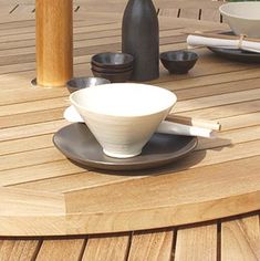 a wooden table topped with bowls and chopsticks