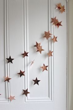 the stars are hanging on the door to be hung by someone's hand and they look like they have been made out of copper foil