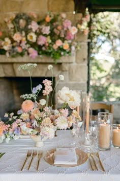 the table is set with flowers and candles