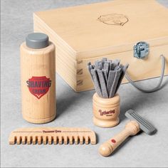 a wooden box with two razors, comb and other items