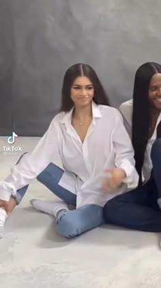 two women sitting on the floor with their legs crossed