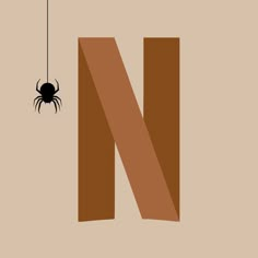 the letter n with a spider hanging from it's side on a beige background