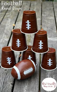 football paper cups sitting on top of a wooden table