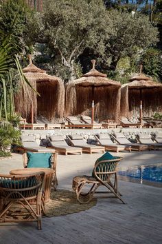 lounge chairs and umbrellas are set up by the pool