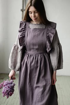 Victorian style apron with flutter sleeves is made from 100% soft and washed linen. Details: - Composition: 100% Oeko-Tex certified linen - Colour: mauve - Cross back - Length - 124 cm (49 inches) - Adjustable with buttons - Size: One size - Light weight linen - Linen care: machine wash gentle; tumble dry low, ironing optional - The price is for one pinafore dress, other pictured items are not included Measurements: Length from waist down: 80 cm (31,4 in) Chest width: 24 cm (9,4 in) without wing Linen Apron Pinafore, Linen Pinafore Dress, Pioneer Clothing, Linen Pinafore Apron, Linen Pinafore, Cottagecore Clothes, Pinafore Apron, Apron For Women, Vintage Apron