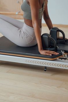 a woman sitting on top of an exercise mat