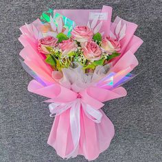 a bouquet of roses wrapped in pink paper