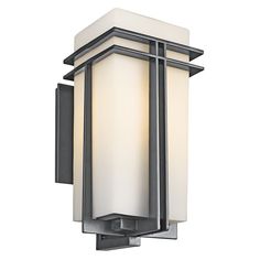 This 1 light wall lantern from the Tremillo(TM) collection offers a smooth, clean profile. Double lines of Black finish form sleek perpendiculars that contrast well with the pleasant ambience of Satin Etched Cased Opal Glass. This design will mark any walkway or porch with sleek sophistication and well-balanced grandeur. Kichler Tremillo 20.2500-Inches H Black Hardwired Outdoor Wall Light | 49203BK Light Posts Outdoor, Exterior House Lights, Wall Sconces Modern, Light Posts, Outdoor Porch Lights, Porch Lights, House Lights, Exterior Lights, Black Outdoor Wall Lights