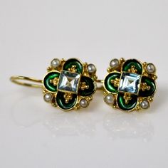 This unique Arts & Crafts Movement design showcases an onyx, iolite, blue topaz, emerald, or garnet set in a cloverleaf of emerald-green or royal blue enamel work, accented with cultured pearl. 24k gold over sterling silver. European back for pierced ears. Size: 3/4 inch. Museum Jewelry, Desi Jewellery, Movement Design, Big Jewelry, Flowers Jewelry, Historical Jewellery, Laurel Burch, Sparkly Things, Garnet Earrings