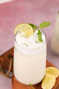 a drink with lemon and mint garnish on a cutting board